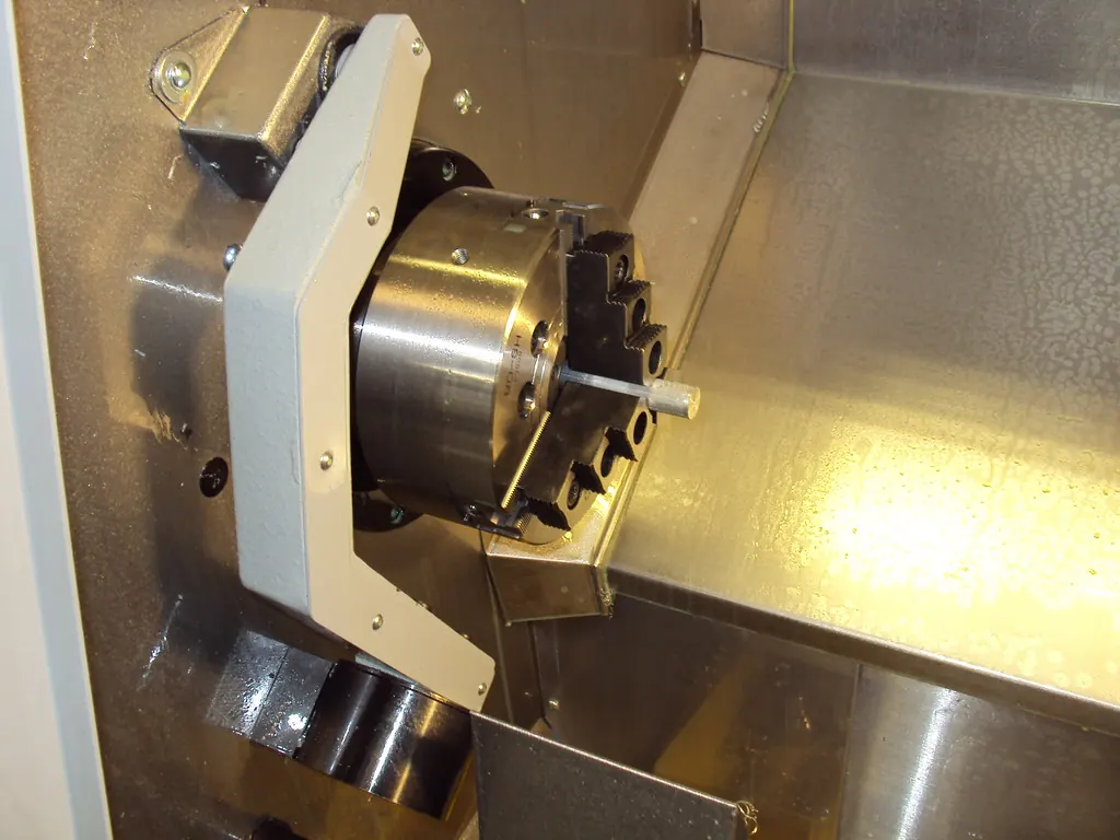 The chuck and turret inside the enclosure of a CNC lathe