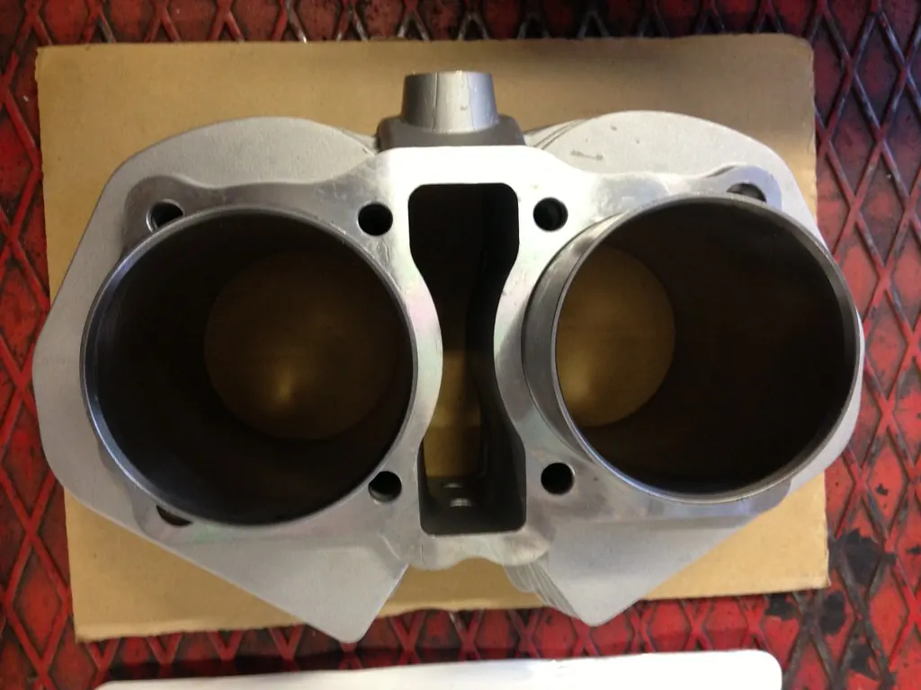 A twin-cylinder engine barrel with freshly machined bores, seen from above